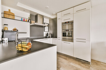 a modern kitchen with black counter tops and white cabinets in the photo is taken from the front end of the room