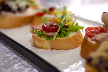 sandwich with dried meat and microgreens on pieces of white baguette - Powered by Adobe