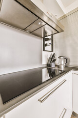 a modern kitchen with white cabinets and black counter tops on the wall behind it is a stainless range hood that has been installed