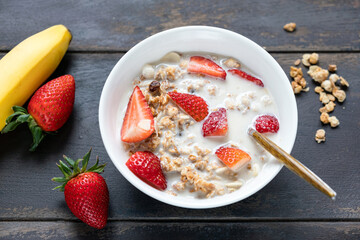 Breakfast granola cereals bowl with oat milk and strawberries. Healthy vegan summer breakfast
