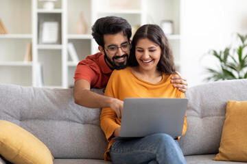 Happy Young Indian Spouses Shopping Online With Laptop At Home
