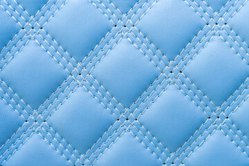 Rough textured surface of blue stitched leather with selective focus. Background or backdrop. Design blank