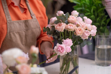florist hands close up artfully combines pink roses and peony flowers to create a stunning bouquet that exudes beauty and elegance