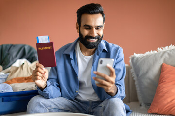 Indian Tourist Man Booking Tickets Online Via Smartphone At Home