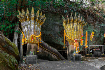 Khong Chiam District Ubon Ratchathani, Thailand - March 5, 2023: Silver Naga and Golden Naga creeping up from the mouth of the cave at the Tham Pharaiya Temple