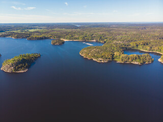 Fototapeta na wymiar Aerial drone view of circle sea fish farm cages and round fishing nets, farming salmon, trout and cod, feeding the fish a forage, with Scandinavian lake landscape and forest island, a summer day