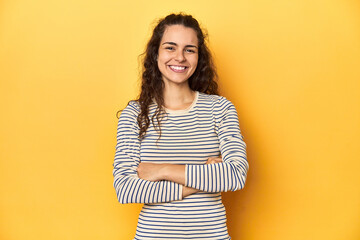 Obraz premium Young Caucasian woman, yellow studio background, who feels confident, crossing arms with determination.