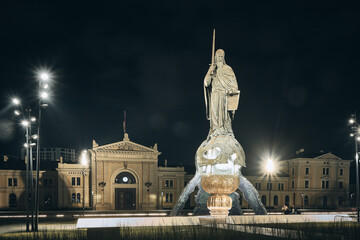 Fototapeta na wymiar Monument of Stefan Nemanja at Sava square captured with long exposure in the evening opposite old Belgrade Main railway station building in the background. Belgrade, Serbia