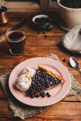 One Slice of Amelanchier Berries Galette and Ice Cream on Plate with Glass of Coffee
