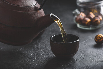 Pouring ready red tea into tea bowl