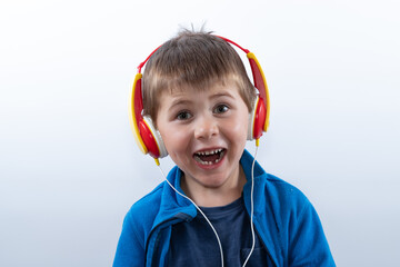 Kleiner fröhlicher Junge hört Musik über Kopfhörer