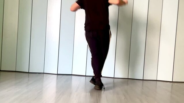 slow motion video of an unrecognizable guy dancing jumpstyle