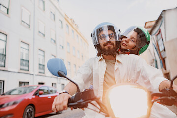 Happy young couple in protective hats are riding on vintage scooter in the Lisbon street