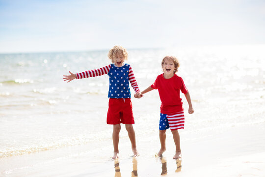 Kids with American flag on beach. 4th of July.