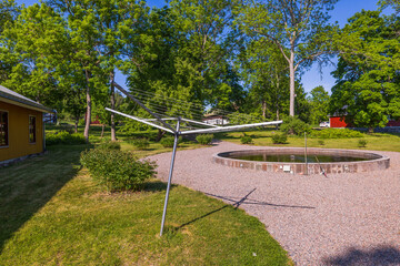 View of metal outdoor clothes dryer on backyard on green trees background. Sweden.