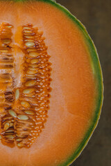 close up of cut half cantaloupe fruit with seeds