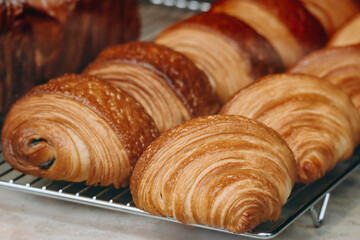 Close-up of fresh and beautiful french pastries (croissants, pains au chocolat) in a bakery showcase