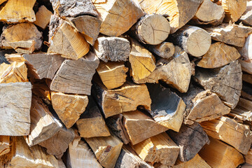 Pile of firewood, stacked dry chopped firewood logs . Preparation of fiewood for winter. Wooden background, natural texture.