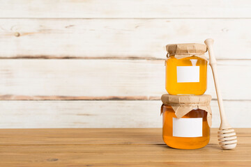 Jars with honey on wooden table. Mock up design