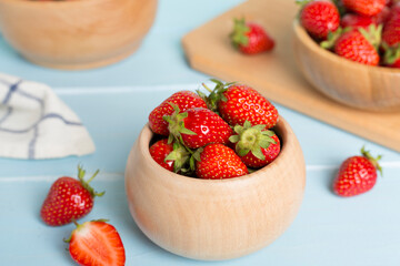 Fresh strawberries in bowl on wooden table
