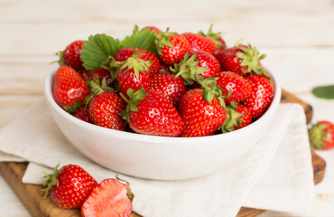 Fresh strawberries in bowl on wooden table