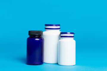 Plastic bottles for vitamins on color background