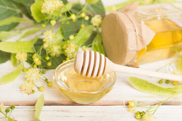 Linden honey with leaves and flowers on wooden table