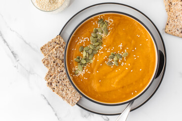 A plate with pumpkin soup puree, pumpkin and sesame seeds. Autumn menu. 