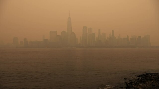 Lower Manhattan city skyline and river in smoky orange fog