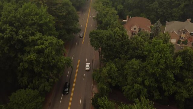 Aerial shot of red car driving on foggy forest road