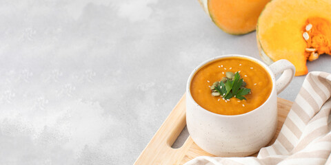 A mug of warm pumpkin soup. The concept of the autumn menu. Autumn recipes. Copy space