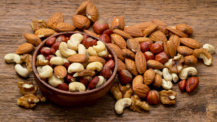 mix of nuts on a wooden table - generative ai