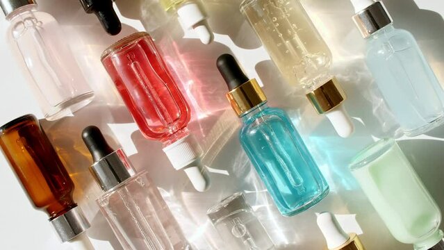 Glass cosmetic bottles with pipette on white background. Women's cosmetics skincare. Sample of packaging for design, beauty product, advertising.4k. High quality 4k footage