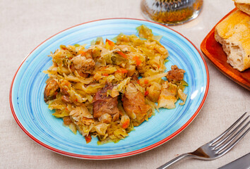 Delicious meat dish - pork with stewed cabbage served on plate. High quality photo