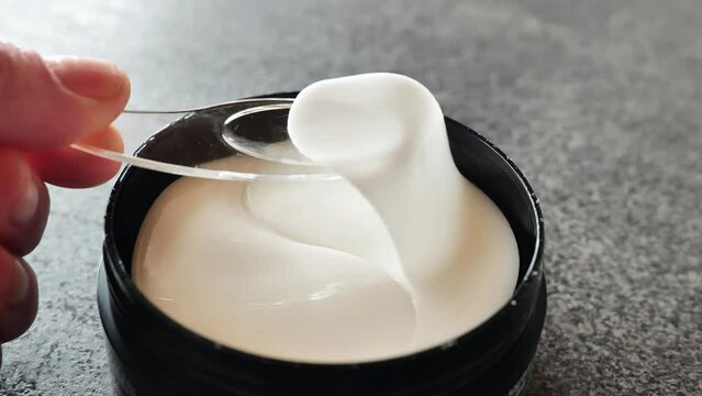 Eyelid Care. Hydrogel cosmetic eye patches in a black jar. hand takes a hydrogel white patch. 4k footage