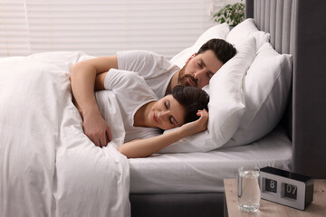 Lovely couple sleeping together in bed at home