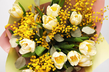 Bouquet of beautiful spring flowers on light grey background, top view