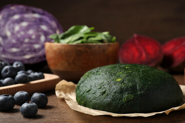 Dough painted with natural food coloring and ingredients on wooden table, closeup