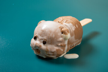 cute tiger shape popsicle starts melting on dark green background