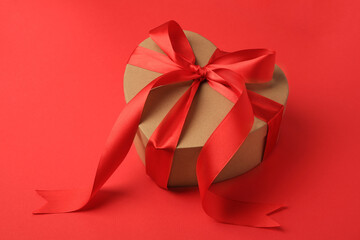 Beautiful heart shaped gift box with bow on red background