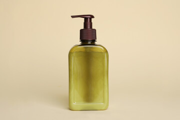 Bottle of face cleansing product on beige background. Space for text