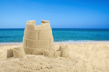 Sand castle on ocean beach, space for text. Outdoor play