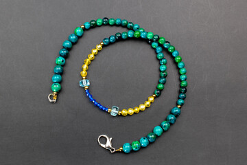Colorful gemstone crystal beads necklace on black, unique handmade jewelry background, promotional photo for an online jewelry store