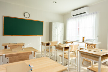 Shot of empty classroom with chairs under desks in elementary school. 