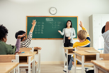 Group of student learn with teacher in classroom at elementary school.