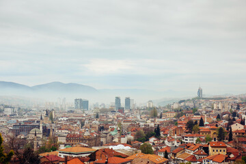 Obraz premium Panoramic view of the spring city of Sarajevo, Bosnia and Herzegovina. A trip to a European Balcan city in the mountains with orange roofs