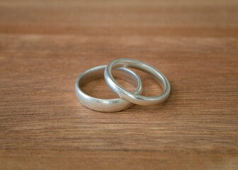 Wedding band rings on wood surface isolated. White gold metal. Copy space.