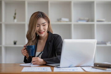 young asian woman sitting and taking note at house. Happy smiling working online, Freelance work at home
