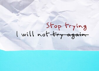 Crumpled paper on blue background with handwritten text I WILL NOT TRY AGAIN, changed to I WILL NOT...