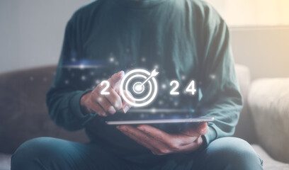 2024 business planning and strategy concept, businessman pointing virtual icon  year 2024 target darts working on smartphone, marketing financial and research analysis, investment trends next new year